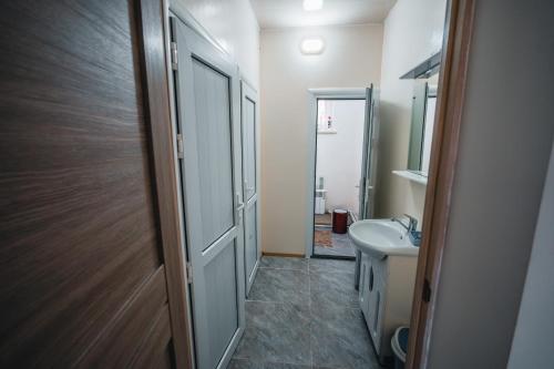 Un baño con lavabo, inodoro y espejo. en Sarysoul Mountainlodge / Pamirextreme, en Sary-Tash