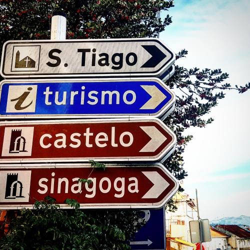a group of street signs on a pole at Casa Dr. Saba in Belmonte