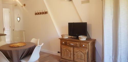 une salle à manger avec une table et une télévision sur une armoire dans l'établissement Chez nous, à La Bollène-Vésubie