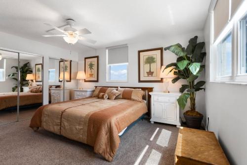 a bedroom with a bed and a ceiling fan at 501 Shores of Madeira in St. Pete Beach