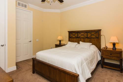 a bedroom with a bed and two night stands with lamps at Spacious Vista Cay Condo near Universal Studios in Orlando