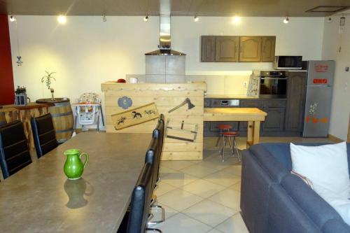 un salon avec une table et une cuisine dans l'établissement Gîte du cheval blanc, à Arçon