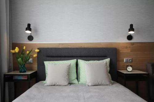 a bedroom with a large bed with two white pillows at Studio Four Seasons with parking place in Gdańsk