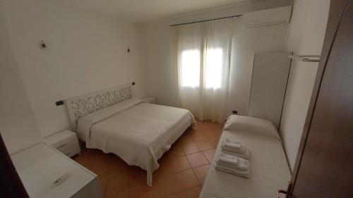 ein kleines Schlafzimmer mit einem Bett und einem Fenster in der Unterkunft Don Diego Apartment Orosei in Orosei