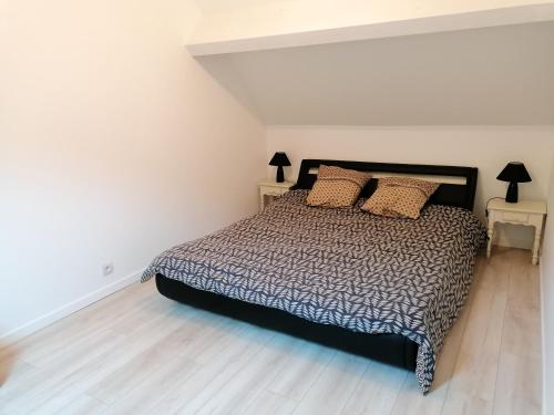 une chambre avec un lit et deux tables de nuit dans l'établissement Maison de charme à Sainte-Geneviève-lès-Gasny avec jardin paisible, à Sainte-Geneviève-lès-Gasny