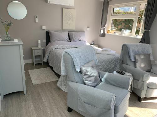 a bedroom with a bed and a chair and a couch at Wisteria Lodge in Bath