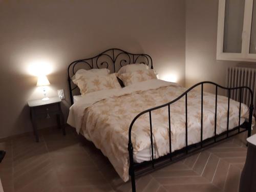 ein Bett in einem Schlafzimmer mit zwei Tischen und zwei Lampen in der Unterkunft Les ROSEAUX A la Campagne au centre des chateaux de la Loire in Feings