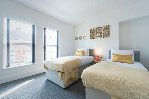 ハルにあるWGcDDE Large 3 Bedroom House - Close to MKM Stadium & A63 - Gardenのベッドが2つと窓がある白い部屋