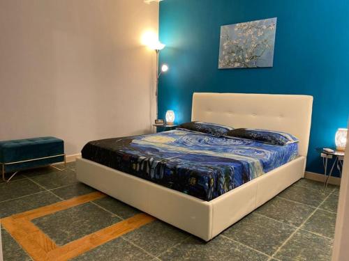 a bed in a room with a blue wall at Iris Apartment in Bari