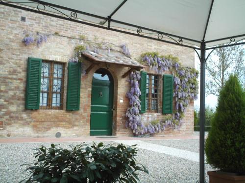 a brick building with a green door and windows at Agriturismo Il Poggiarello in Siena