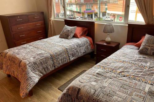 a bedroom with two beds and a window at Panchi´s House in Baños