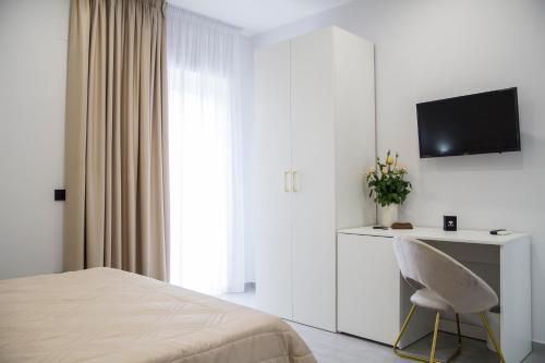 a bedroom with a bed and a chair and a television at Maison de Julia Pompei in Pompei