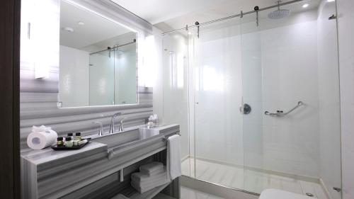 a white bathroom with a shower and a sink at Recoleta Grand in Buenos Aires