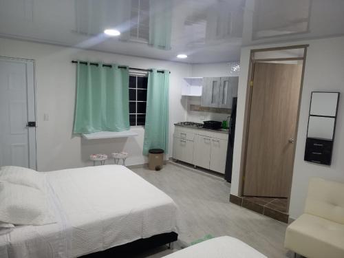a bedroom with a white bed and a kitchen at SWEET BREEZE in San Andrés