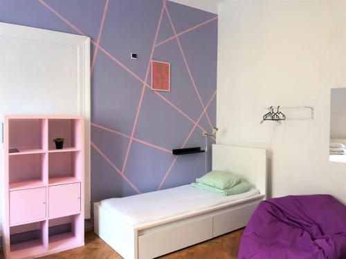 a room with a bed, a desk and a painting on the wall at Travel&Joy backpackers in Prague