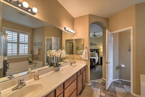 a bathroom with two sinks and a large mirror at Spacious Surprise Home 6 Mi to Wildlife World Zoo in Surprise