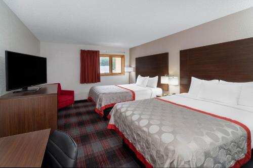 a hotel room with two beds and a flat screen tv at Ramada by Wyndham Maggie Valley in Maggie Valley