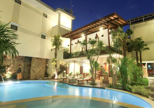 a swimming pool in front of a building at Manggar Indonesia Hotel in Kuta