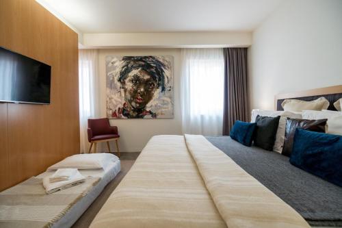 une chambre d'hôtel avec un grand lit et une télévision dans l'établissement Welcome Madeira Apartments, à Funchal