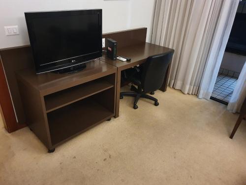 een bureau met een televisie en een stoel in een kamer bij Hotel Bonaparte Blue Residence F 209 in Brasilia