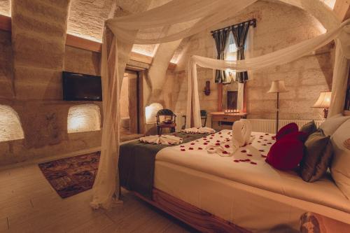 a bedroom with a bed in a stone room at Rose Valley Hotel in Goreme