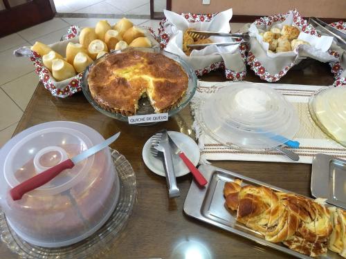 a table with pies and other food on it at Pousada Finlândia in Penedo