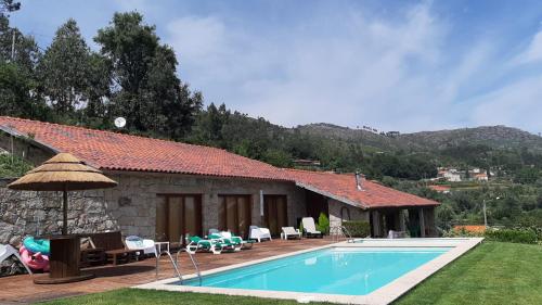 a house with a swimming pool in the yard at Casa dos Cinco - Gerês in Terras de Bouro