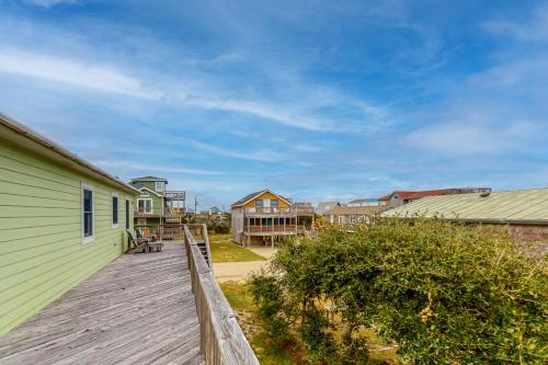 a wooden deck next to a building with a house at Beach Dreamer #4-BB in Buxton