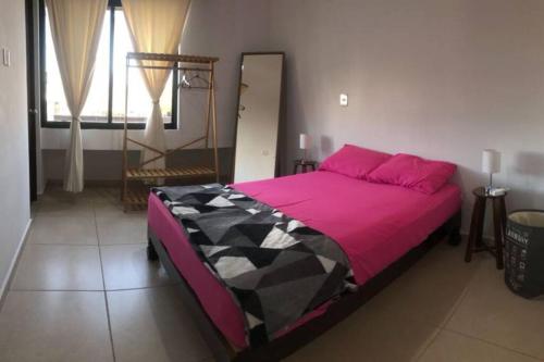 1 dormitorio con 1 cama grande con sábanas rosas en Nice House w/ shared pool and close to the beach at Mazatlan, en La Florida