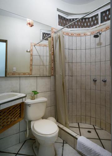 a bathroom with a toilet and a sink and a shower at Las Olas in Máncora