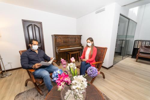 a man and woman wearing masks sitting in chairs with a piano at Samana Hotel in Arequipa