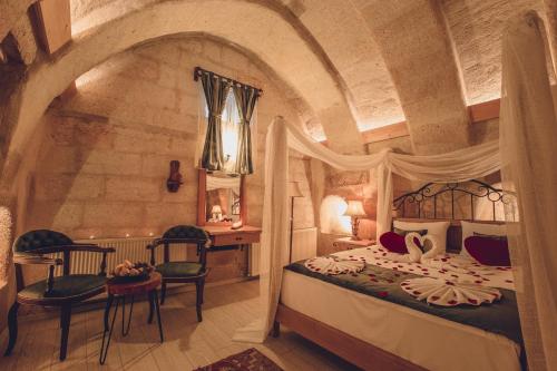 a bedroom with a bed and a table and chairs at Rose Valley Hotel in Goreme