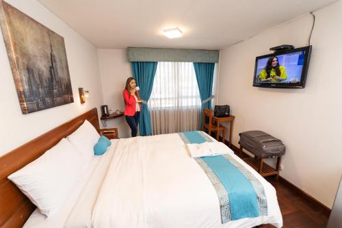 a woman standing in a hotel room with a bed at Samana Hotel in Arequipa