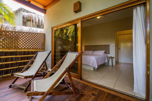 a room with two chairs and a bed and a mirror at Las Olas in Máncora