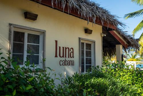 
a building with a sign on the front of it at Caribbean Beach Cabanas - A PUR Hotel in Placencia
