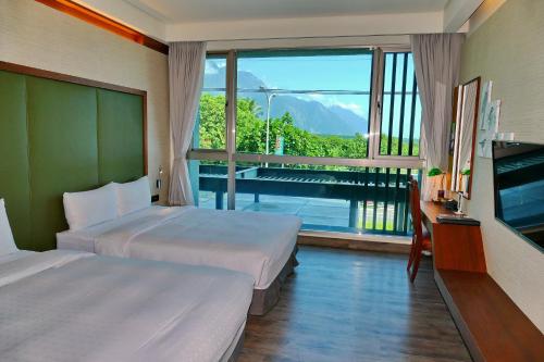 新城鄉的住宿－太魯閣立閣人文旅店，酒店客房设有两张床和大窗户。