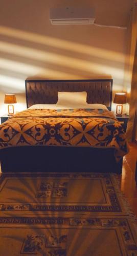 a bed in a bedroom with two lamps on the floor at شقة كلاسيك بمساحة خضراء قريبة من الحصري in 6th Of October