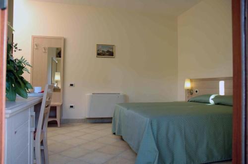 a bedroom with a bed and a table and a mirror at Hotel Santa Rosa Centro Vacanze in Sangineto