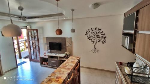 a living room with a tree mural on the wall at Apartamento 05 Vivendas do Serrano - Lençóis in Lençóis