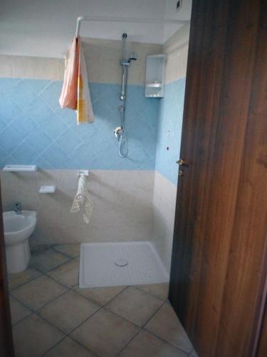 a bathroom with a shower and a toilet and a door at Hotel Santa Rosa Centro Vacanze in Sangineto