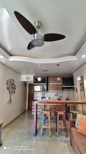 a living room with a ceiling fan and a kitchen at Apartamento 05 Vivendas do Serrano - Lençóis in Lençóis
