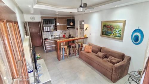 a living room with a couch and a kitchen at Apartamento 05 Vivendas do Serrano - Lençóis in Lençóis
