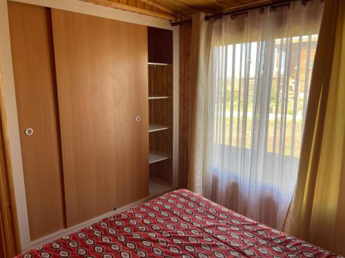 a small bedroom with a bed and a window at Cabañas y Centro Eventos Leyda in San Antonio