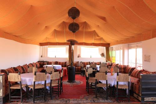 un comedor con mesas y sillas y una tienda grande en Luxury Berber Camp, en El Gouera