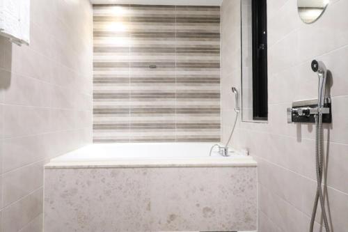 a bathroom with a shower with a bath tub at Hotel Marcher in Busan
