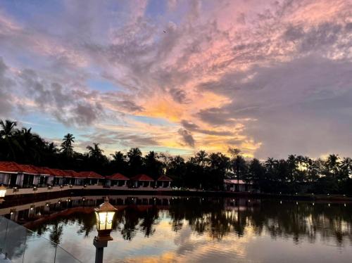 a sunset over a body of water with a street light at Veda5 Wellness Retreat & Spa in Old Goa