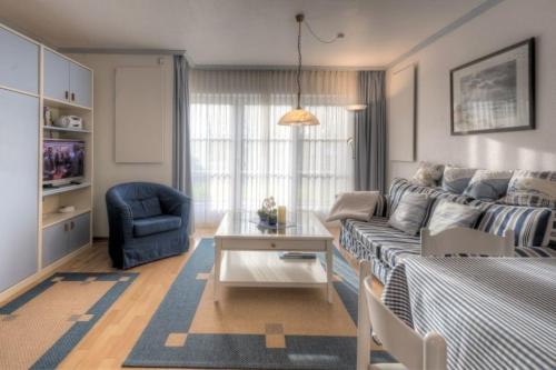 ein Wohnzimmer mit einem Sofa und einem Stuhl in der Unterkunft Seeschlößchen Nr 6 in Büsumer Deichhausen