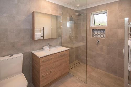 y baño con aseo, lavabo y ducha. en Dunsborough Beach Cottages en Dunsborough