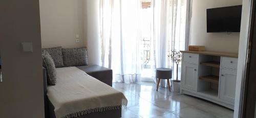 a small living room with a couch and a tv at Happy Anchor Apartments in Kallithea Halkidikis
