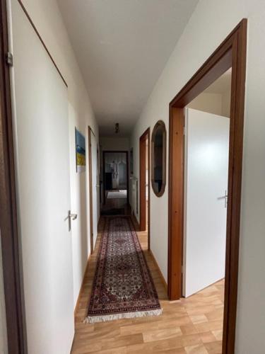 a hallway with an open door and a rug at Vier Jahreszeiten 4JZ Haus 1 Whg 71 in Großenbrode